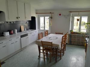 圣保罗德费努耶hOMe-Shanti Galamus的一间带桌椅的厨房和一间带白色橱柜的厨房