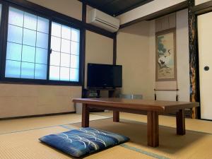 三好市Iya Kankou Ryokan的客厅配有木桌和电视。