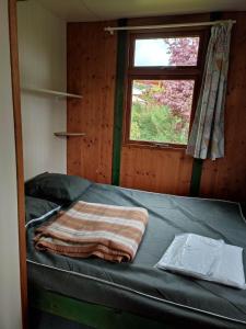 拉图多韦尔尼Camping la Vallée的窗户和毯子的房间里一张床位