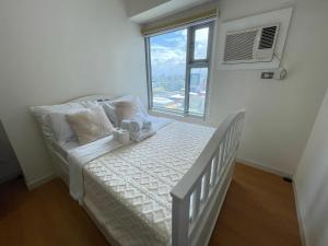 马尼拉8 Adriatico的一间小卧室,配有一张带窗户的床