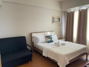 马尼拉8 Adriatico的一间卧室配有一张床和一张蓝色椅子