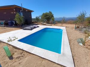 瓦尔帕莱索Mini casa en lo alto de la montaña的庭院中间的一个蓝色游泳池