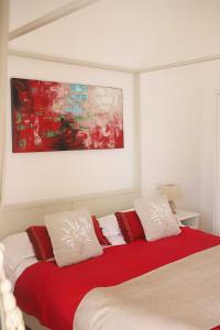 卡普里Casa Tarantino Charming apartments的一间卧室配有红色和白色枕头的床