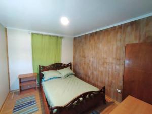 瓦尔迪维亚Chalet Valdivia的一间卧室设有一张床和木墙