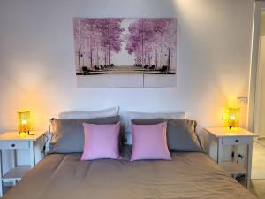马罗内Angelo&Marì Mountain Lake Iseo Hospitality的一间卧室配有一张带两个粉红色枕头的床