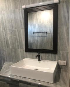 Koh Loneแครินโฮมสเตร์的浴室设有白色水槽和镜子