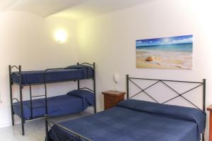 费拉约港Bed & Bike Casa dei Papi的卧室配有两张双层床,海滩上饲养着一只狗