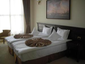克拉约瓦莱克斯顿酒店的酒店客房,配有两张带毛巾的床