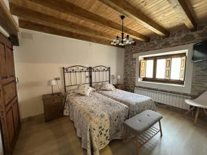 YanguasHotel Rural El Rincón de Marta的一间卧室设有一张床和木制天花板
