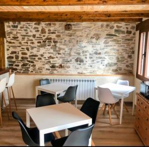 YanguasHotel Rural El Rincón de Marta的一间带桌椅和石墙的餐厅