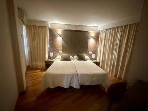 莫切卡斯塔玛利酒店的一间卧室配有一张带白色床单和窗帘的床