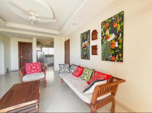 Mwembe MaepeBest View Malindi Guest House的客厅配有沙发和墙上的绘画