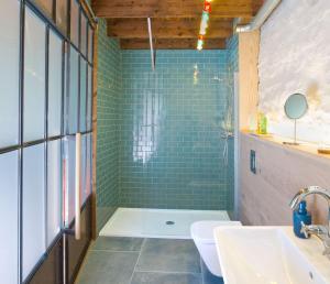 ÉvranLe Moulin du Mottay的浴室设有绿色瓷砖和淋浴。