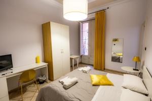 卡塔尼亚Promenade B&B的一间卧室配有一张床、一张书桌和一个窗户。