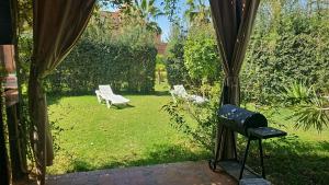 马拉喀什atlas golf resort marrakech " Maison à 03 chambres avec jardin privé "的享有花园的景致,庭院设有长凳