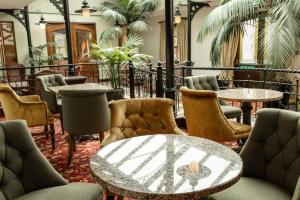 斯特拉诺勒Kee's Hotel的大堂设有桌椅,种植了棕榈树。