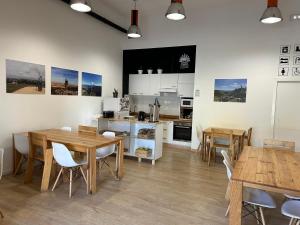 圣地亚哥－德孔波斯特拉Albergue SCQ的厨房以及带木桌和椅子的用餐室。