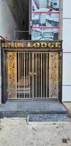 瓦朗加尔Supreme Hotels 2.0的建筑物前的大门,上面有标志