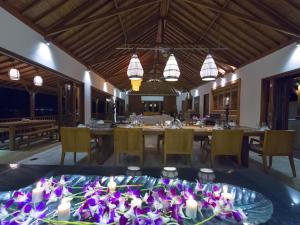 甘地达萨Villa Asada by Elite Havens的用餐室配有带紫色鲜花和蜡烛的桌子