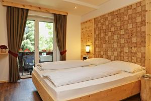 萨伦蒂诺奥林匹亚酒店的一间卧室设有一张带砖墙的大床