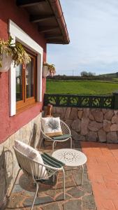 La AcebosaCasa de campo La Casuca Del Monje的庭院设有两把椅子、一张桌子和一扇窗户。