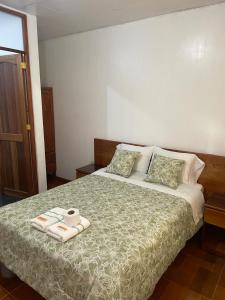 奥克萨潘帕Hospedaje Familiar Laos的一间卧室配有一张床,上面有两条毛巾