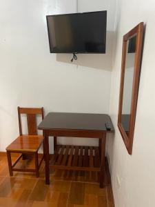 奥克萨潘帕Hospedaje Familiar Laos的桌子、椅子和墙上的电视