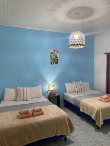 Puerto LibertadHotel Puerto Libertad - Iguazú的蓝色墙壁客房的两张床