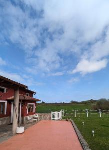 La AcebosaCasa de campo La Casuca Del Monje的白色围栏和田野的房子