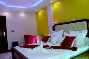 雅温得Matcheu palace Hôtel的一间卧室配有一张带红色和白色枕头的大床