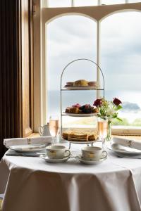 廷塔杰尔卡米洛城堡酒店的一张桌子,上面有两个茶杯和蛋糕
