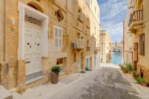 森格莱阿Charming Maltese Townhouse in Senglea的老镇一条带白色门的小巷