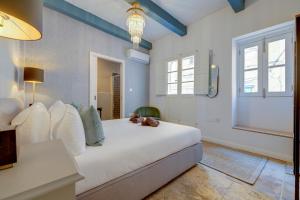 森格莱阿Charming Maltese Townhouse in Senglea的卧室配有一张白色的床,上面有一只动物填充物