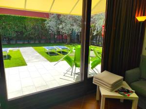 巴多利诺Bardolino Wein Apartments的透过窗户可欣赏到庭院美景,配有桌椅