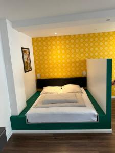多特蒙德童多瑟公寓的一间卧室配有一张黄色墙壁的床