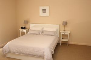 Port Hughes灯塔 - 海滨度假屋的一间卧室配有白色床和2个床头柜