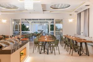 卡拉马孔扎金索斯岛卡拉马基海滩酒店的用餐室配有木桌和椅子