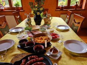 Pierzchno潘索耶纳西克花园旅馆的餐桌上放有盘子和碗的食物