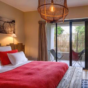 马瑟伊兰Domaine Tarbouriech, Hôtel & Spa的一间卧室配有一张带红色毯子的大床