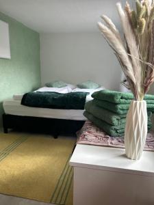 ObergurigFerienhaus Lavendel的一间卧室,配有一张带花瓶的床铺,位于柜台上