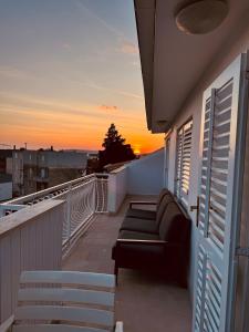 斯普利特Apartman Bačvice near the beach的阳台配有沙发,享有日落美景。