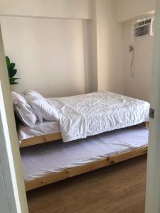 马尼拉Fia Horizons @ Infina South Tower的卧室配有2张双层床和白色床单