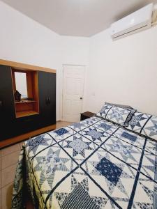 圣米格尔casa familiar san miguel的一间卧室配有一张带蓝色和白色被子的床
