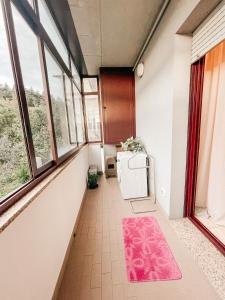 圣马力诺B&B Da Noi的走廊上设有窗户和粉红色地毯