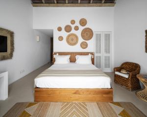 孔波尔塔Quinta Da Comporta - Wellness Boutique Resort的一间卧室配有一张大床和一把椅子