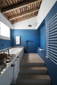 孔波尔塔Quinta Da Comporta - Wellness Boutique Resort的浴室拥有蓝色的墙壁和带浴缸的楼梯。