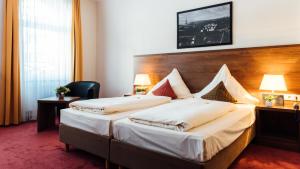 伍珀塔尔阿尔卡德酒店的酒店客房设有两张床和两盏灯。