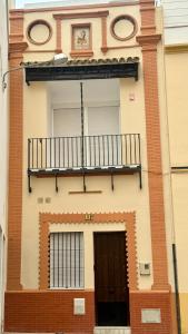 塞维利亚Casa Boutique Plaza de Armas -Townhouse-的带阳台和门的建筑
