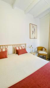塔维拉Quinta Almargem Lusitano - Farm House的卧室配有带红色枕头的大型白色床