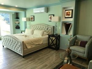 巴亚尔塔港South Shore Villa Armonia Luxury Boutique的一间卧室配有一张床、一张沙发和一把椅子